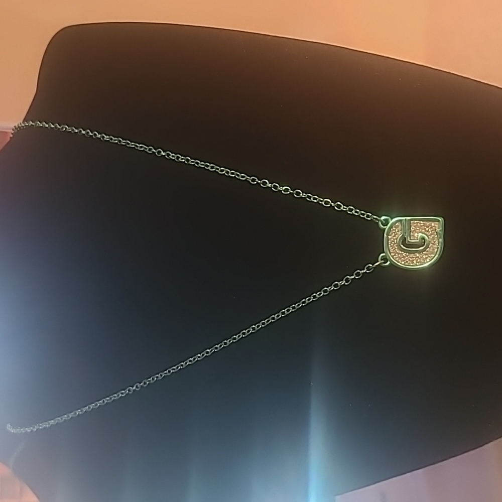 A Green Necklace With The Letter G Pendent